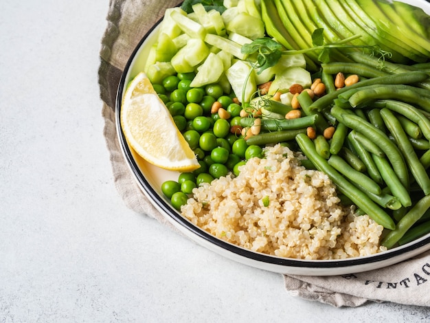 Tazón de quinua con judías verdes, guisantes, pepino, aguacate y piñones