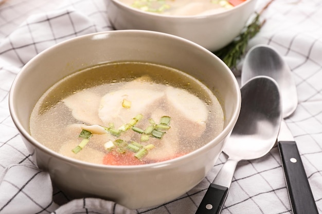 Tazón con sabroso caldo y albóndigas en la mesa