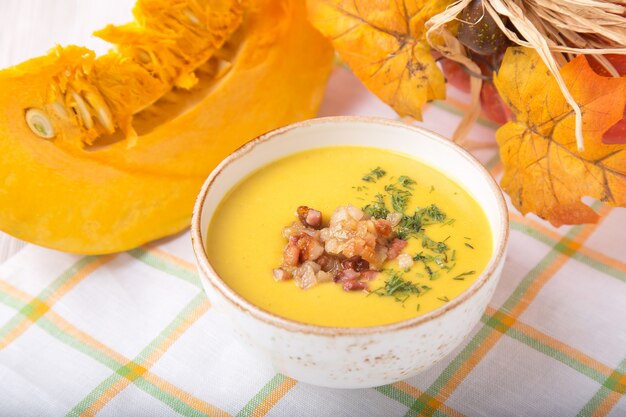 Tazón de sopa de calabaza con cebolla frita y tocino