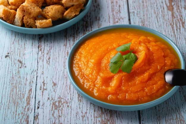 Tazón de sopa de calabaza con picatostes de queso y perejil