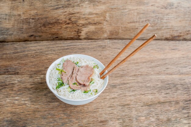 Tazón de sopa de carne vietnamita tradicional Pho Bo en el oscuro fondo de madera vieja