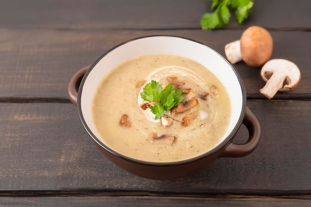 Tazón de sopa de crema de champiñones sobre fondo de madera