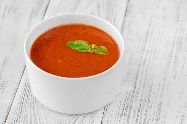 Tazón de sopa de crema de tomate en la mesa de madera