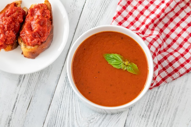 Tazón de sopa de crema de tomate en la mesa de madera