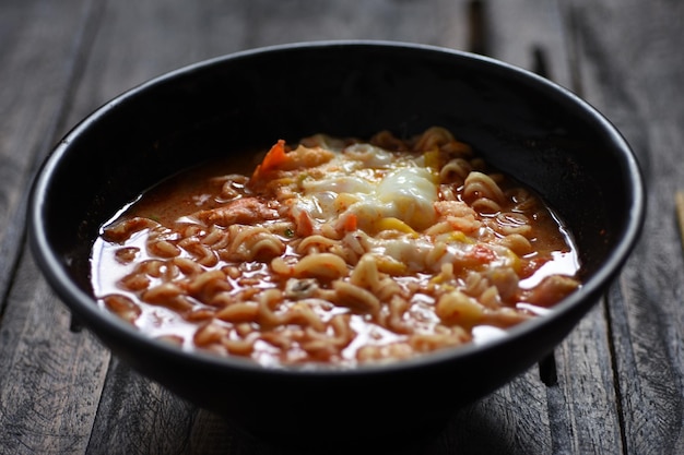 un tazón de sopa de fideos instantáneos, cocido picante con chile y huevo