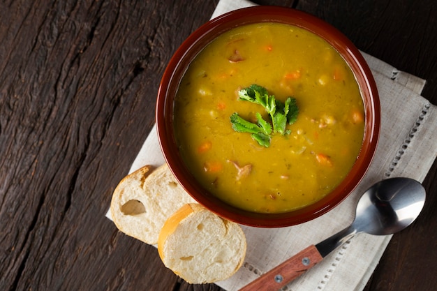 Tazón de sopa de guisantes con sopa de guisantes en la mesa