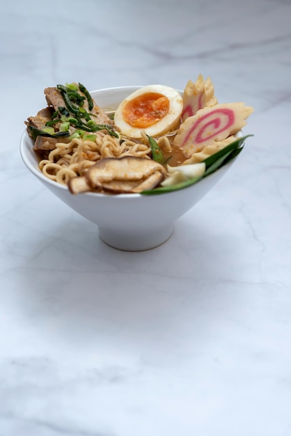 Tazón de sopa de ramen sobre mesa de mármol