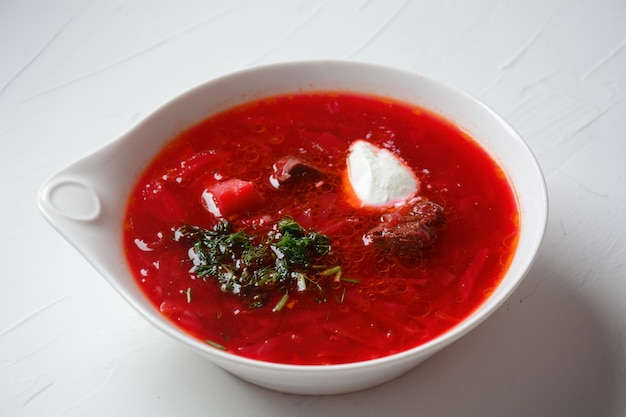 Tazón de sopa de remolacha roja borsch con crema blanca