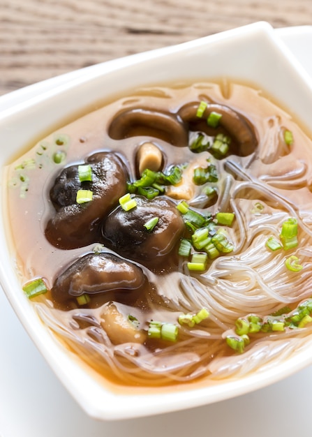 Tazón de sopa de shiitake en la mesa de madera