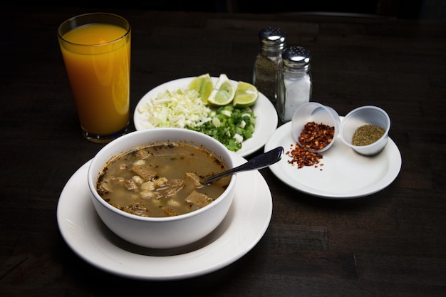 un tazón de sopa se sienta en una mesa al lado de un bol de sopa