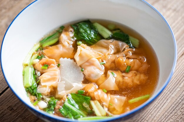 Tazón de sopa, sopa de bola de masa de cerdo y camarones con verduras comida asiática, sopa wonton, comida china