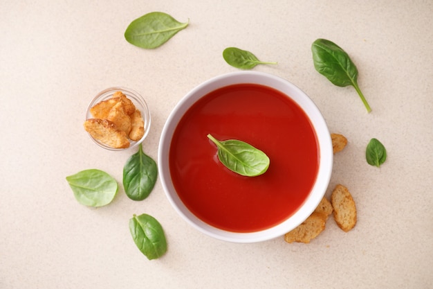 Tazón de sopa de tomate en la vista superior de la mesa de la cocina