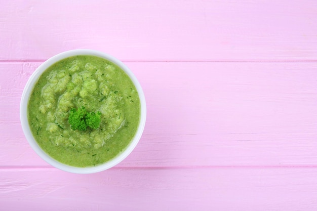 Foto un tazón de sopa de verduras cremosa para bebés en una mesa de madera