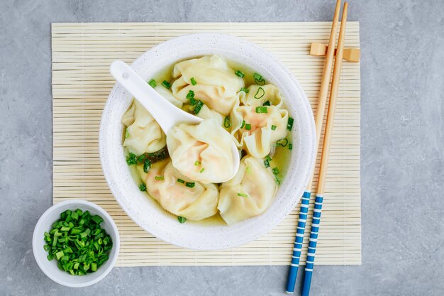 Tazón de sopa de wonton Sopa de wonton de camarones o cerdo con espacio de copia de vista superior de cebolla verde