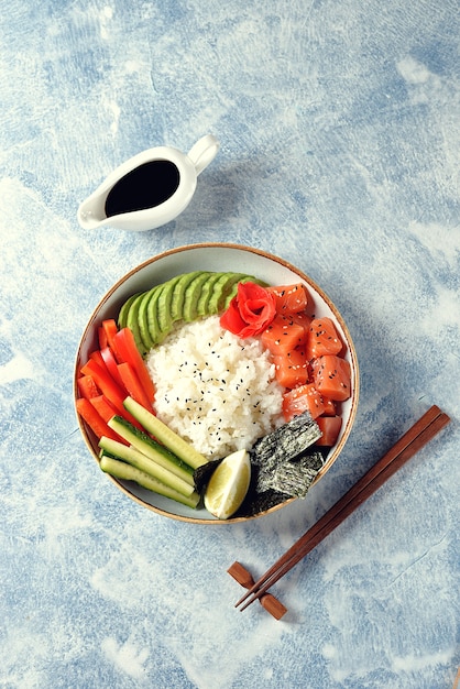 Tazón de sushi con arroz, salmón, aguacate, pepino y sésamo