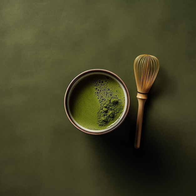 Foto un tazón de té verde al lado de un batidor y un batidor.