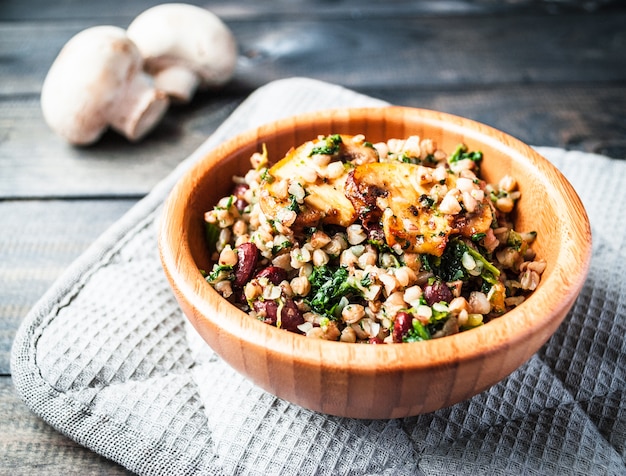 Foto tazón de trigo sarraceno hervido con champiñones fritos, espinacas y frijoles rojos