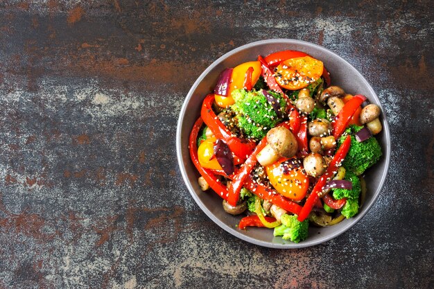 Tazón vegano con ensalada caliente de vegetales y champiñones. Keto almuerzo idea. Brócoli, pimentón, champiñones. Alimentos frescos y saludables sin carne.