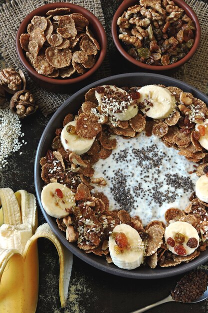 Un tazón de yogur de chía, plátano, semillas y cereales.