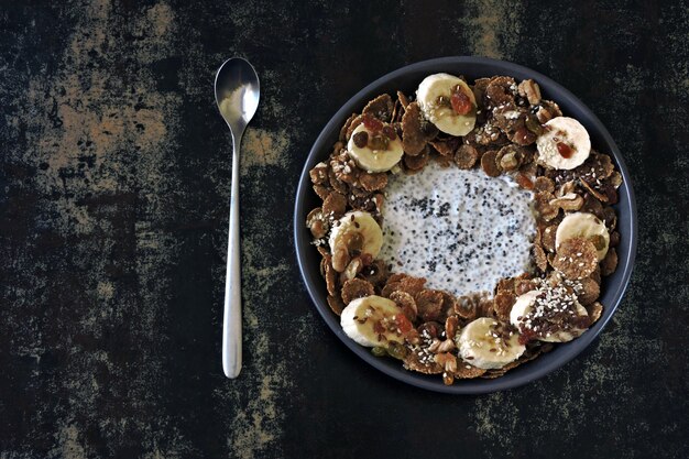 Un tazón de yogur de chía, plátano, semillas y cereales.