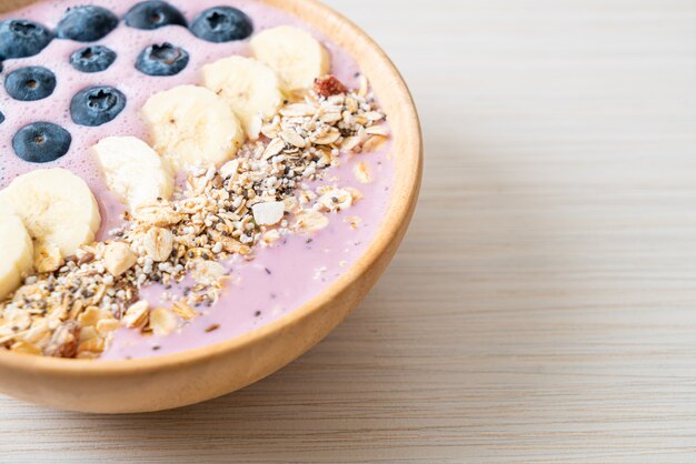 tazón de yogur o batido de yogur con bayas azules, plátano y granola - Estilo de comida saludable