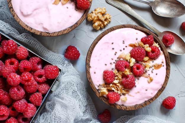 Tazones de batido de frambuesas cubiertos con frambuesas frescas