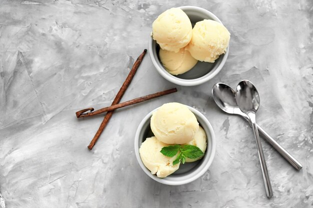 Tazones con deliciosas bolas de helado de vainilla en la mesa