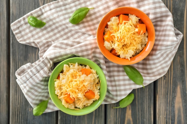 Tazones con delicioso risotto de calabaza en mesa de madera