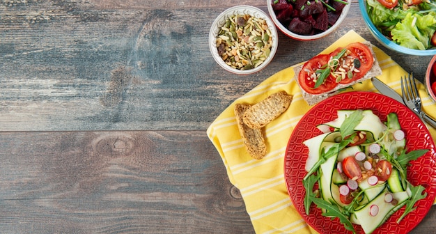 Tazones y plato de ensalada vegana saludable con espacio de copia