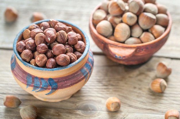 Tazones rústicos de avellanas en la mesa de madera