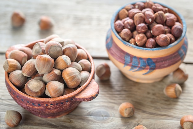 Tazones rústicos de avellanas en la mesa de madera