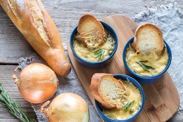 Tazones de sopa de cebolla en la tabla de madera