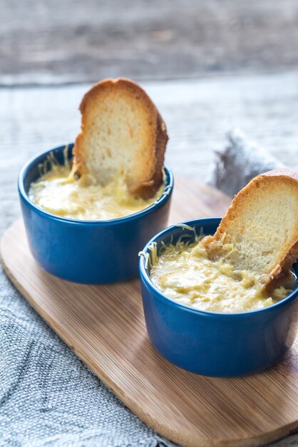 Tazones de sopa de cebolla en la tabla de madera