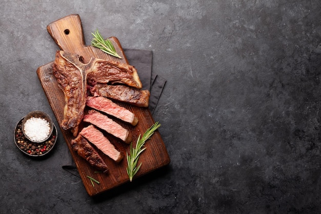Tbone bistec de carne a la parrilla con especias y hierbas Vista superior plana con espacio de copia