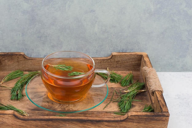 Foto té de aguja de pino en una taza sobre un fondo blanco de textura espacio de copia vacío para el texto bebida caliente