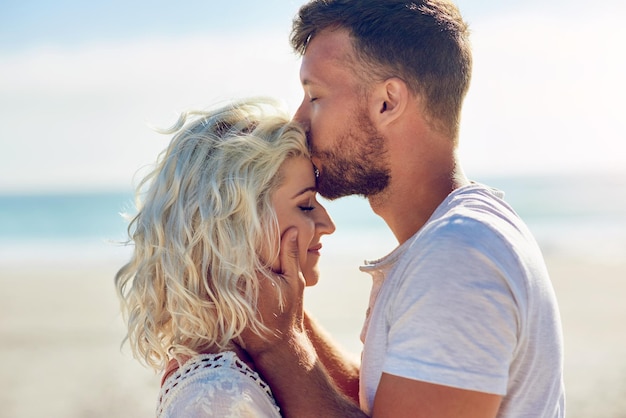 Te amaré hasta que los mares se sequen Captura recortada de una pareja cariñosa pasando el día en la playa