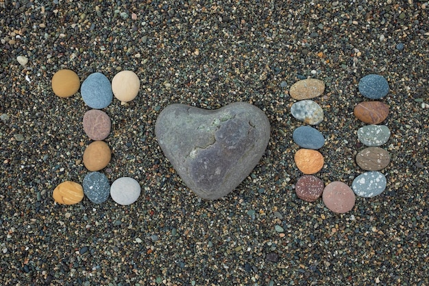 Te amo hecho de piedras en la playa de arena