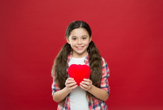 Te amo solo en mi corazón por los siglos de los siglos. Niño pequeño expresando amor en el día de san valentín. Linda chica enamorada. Tener problemas cardíacos y angustia. Niña con corazón rojo. Feliz día de San Valentín.