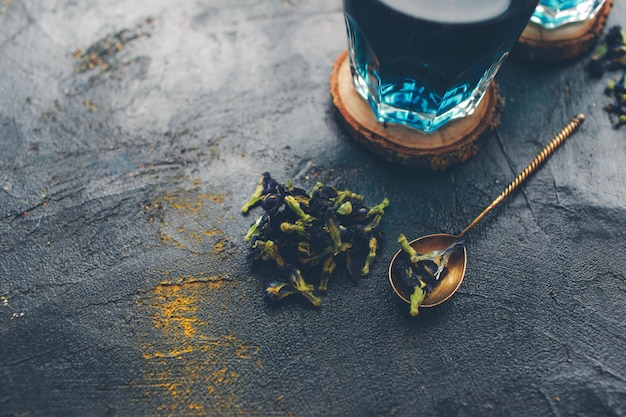 Foto té azul de la flor del guisante de mariposa. detox bebiendo en la mesa oscura. bebida saludable a base de hierbas. té de hierbas azul anchan con lima