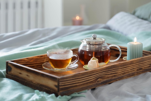 Té en bandeja de madera en la cama en casa