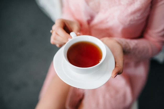 Té bebiendo té negro con tazas de porcelana y una tetera.