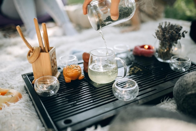 El té blanco se vierte en vasos de vidrio Ceremonia del té por la mañana en el parque