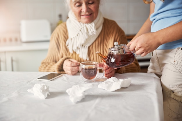 Té caliente para la abuela sintiéndose mal