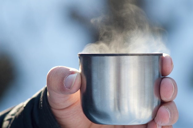 Té caliente al vapor de un termo en la naturaleza vista cercana