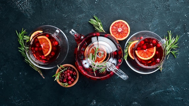 Té caliente con bayas de arándano y naranja En el fondo negro de la cocina Vista superior Espacio libre para el texto