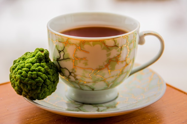 Té caliente con bergamota en mesa de madera en el frío. Invierno.