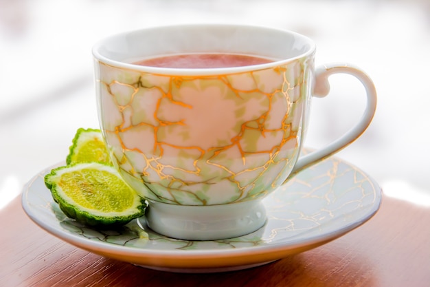 Té caliente con bergamota en mesa de madera en el frío. Invierno.