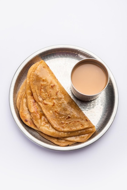 El té caliente Chai Paratha servido con pan plano es una comida tradicional sencilla de India y Pakistán