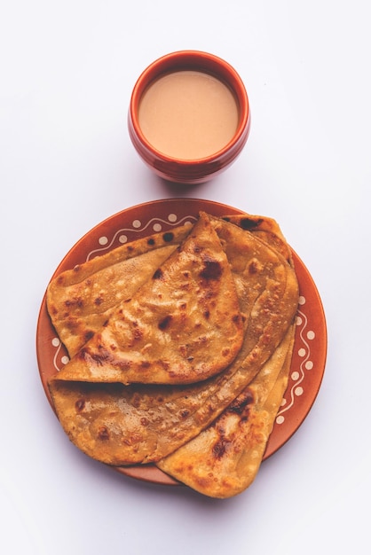 El té caliente Chai Paratha servido con pan plano es una comida tradicional simple de la India y Pakistán