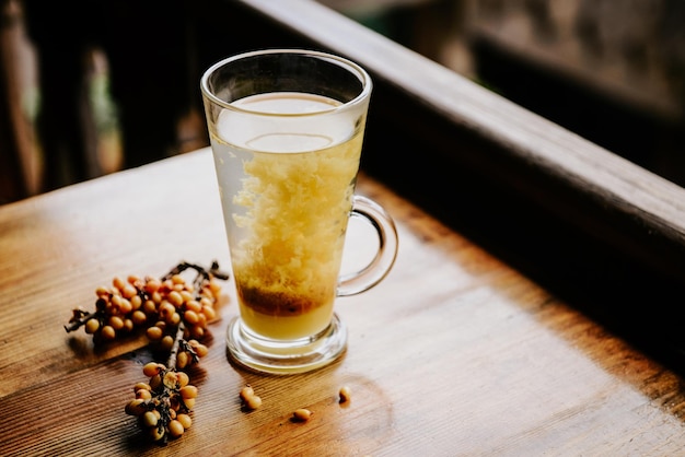 Té caliente con espino cerval de mar en un vaso sobre una mesa de madera en un café